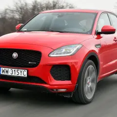 Czerwony Jaguar E-Pace pędzi po drodze, ukazując swoje sportowe linie i charakterystyczny grill.