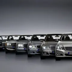 Rząd klasycznych i nowoczesnych Mercedesów klasy E, od starszych modeli po najnowsze, prezentuje ewolucję designu.