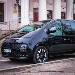 Czarny Hyundai Staria, nowoczesny van, zaparkowany przed budynkiem z kolumnami i schodami.
