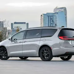Srebrny Chrysler Pacifica z czarnymi felgami na tle nowoczesnych budynków miejskich.