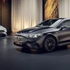 Elegancki, nowy Mercedes CLA w kolorze czarnym i białym prezentuje się na tle miejskiej panoramy.
