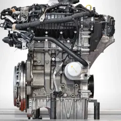 Silnik Ecoboost z bliska, z widocznymi przewodami, filtrem oleju i elementami układu napędowego.