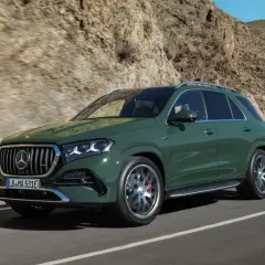Zielony Mercedes GLE 2026 na krętej drodze w górach.