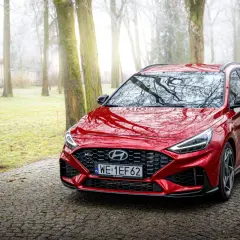 Czerwony Hyundai i30 Wagon N Line na kamienistej drodze w mglistym parku.