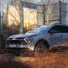 Nowy kia crossover odbija się w lustrzanych panelach, tworząc surrealistyczny krajobraz miejski.