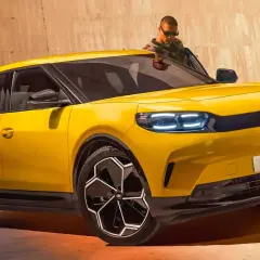 Nowy Ford Capri 2025 w jaskrawym żółtym kolorze, z nowoczesnymi światłami LED i stylowymi felgami. Mężczyzna w okularach wychodzi z samochodu.