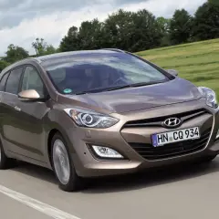 Brązowy Hyundai i30 1.4 benzyna w wersji kombi na drodze. Wiele pozytywnych hyundai i30 1.4 benzyna opinie o tym modelu.