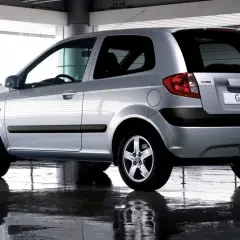 Srebrny Hyundai Getz 1.1 z 2005 roku, widok z tyłu, stoi na mokrej nawierzchni.
