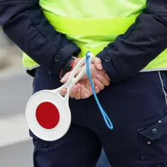 Policjant z tarczą stop. Uważaj na drogach, bo punkty karne 2025 mogą Cię zaskoczyć.