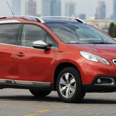 Pomarańczowy Peugeot 2008 na parkingu. Zastanawiasz się, jaki silnik wybrać do tego modelu?