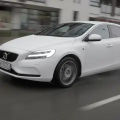 Białe Volvo V40 D3 w ruchu miejskim, na mokrej nawierzchni.