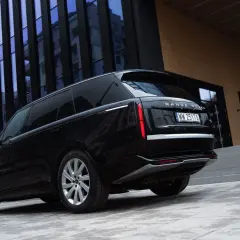 Elegancki czarny Range Rover Autobiography lśni na tle nowoczesnej architektury.