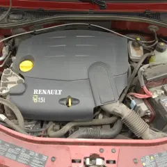 Silnik Renault 1.5 dCi z widoczną pokrywą silnika, akumulatorem Dacia i przewodami.