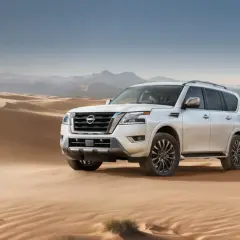 Biały Nissan Armada przemierza piaszczyste wydmy pustyni, gotowy na każdą przygodę.