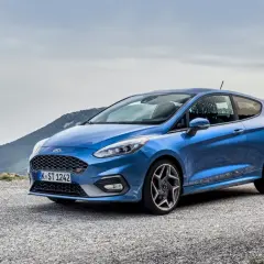 Niebieski Ford Fiesta ST na górskiej drodze, gotowy na każdą przygodę.