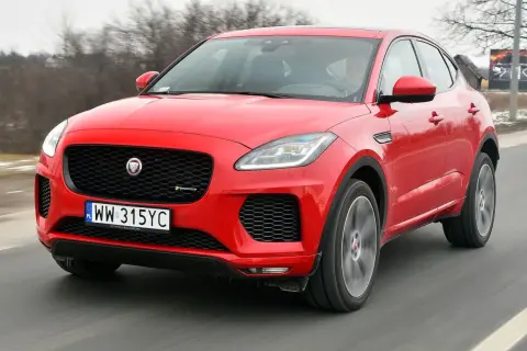 Czerwony Jaguar E-Pace pędzi po drodze, ukazując swoje sportowe linie i charakterystyczny grill.