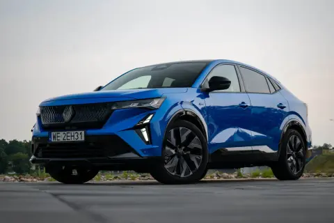 Błękitny Renault Rafale z czarnymi felgami stoi na drewnianym tarasie.