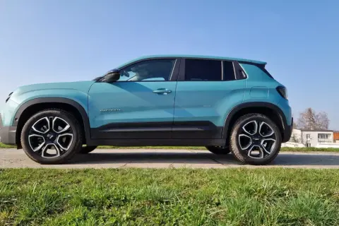 Turkusowy Jeep Avenger na tle błękitnego nieba. Wiele osób szuka jeep avenger opinie, by poznać ten model.