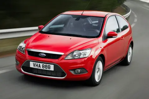 Czerwony Ford Focus MK2 1.6 benzyna w ruchu na krętej drodze.
