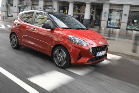 Czerwony Hyundai i10 na miejskim przejściu dla pieszych. Sprawdź atrakcyjną hyundai i10 cena!