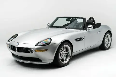 Srebrny kabriolet BMW Z8 na białym tle, z czarnym dachem i wnętrzem. Klasyk motoryzacji.