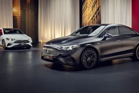 Elegancki, nowy Mercedes CLA w kolorze czarnym i białym prezentuje się na tle miejskiej panoramy.