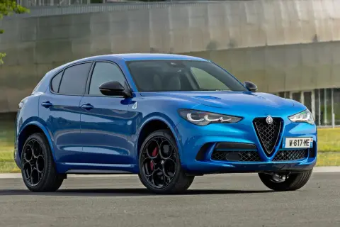 Błękitne Alfa Romeo Stelvio Quadrifoglio z czarnymi felgami i czerwonymi zaciskami hamulcowymi, gotowe do dynamicznej jazdy.