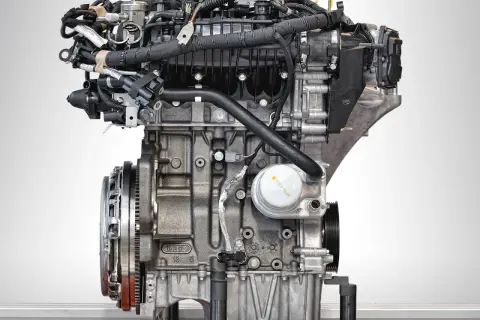 Silnik Ecoboost z bliska, z widocznymi przewodami, filtrem oleju i elementami układu napędowego.