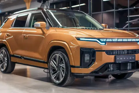 Pomarańczowy SUV z futurystycznym przodem, jeden z nowych koreańskich marek aut.