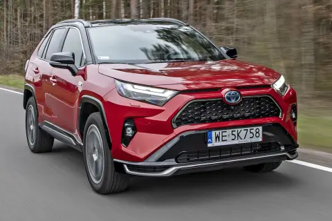 Czerwona Toyota RAV4 Hybrid w ruchu. Sprawdź aktualny toyota rav4 cennik i odkryj możliwości tego SUV-a.