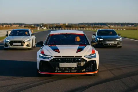 Trzy samochody Audi RS 8 na torze wyścigowym. Biały RS 8 z czerwonymi akcentami na pierwszym planie, za nim biały i czarny RS 8.