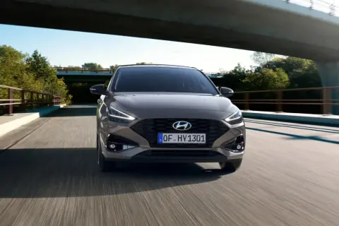 Szary Hyundai i30 1.6 CRDi jedzie po moście wśród zieleni.