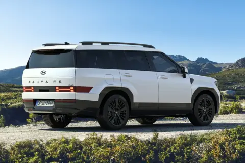 Biały Hyundai Santa Fe 2025 z czarnymi felgami na tle górskiego krajobrazu.