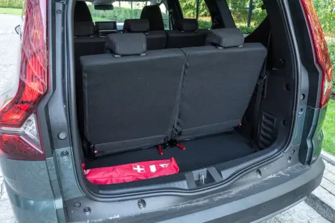 Bagażnik Dacia Jogger z rozłożonymi siedzeniami. W środku apteczka. Dacia Jogger opinie: praktyczny i przestronny.