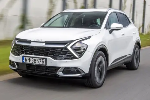 Biały Kia Sportage w ruchu. Wiele osób szuka kia sportage opinie, ten model wygląda obiecująco.