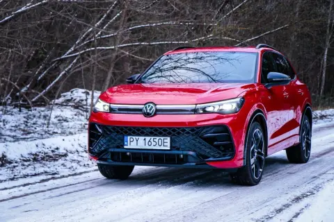 Czerwony Volkswagen Tiguan na śnieżnej drodze. Wiele osób szuka **volkswagen tiguan opinie** przed zakupem.