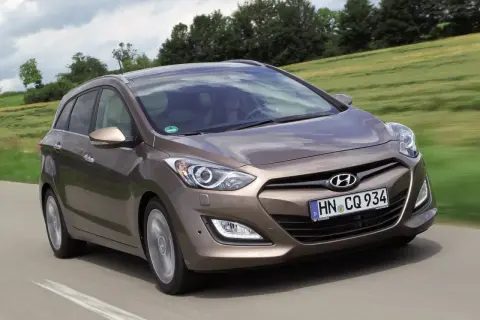 Brązowy Hyundai i30 1.4 benzyna w wersji kombi na drodze. Wiele pozytywnych hyundai i30 1.4 benzyna opinie o tym modelu.