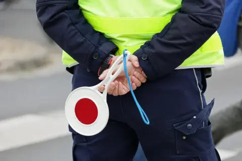 Policjant z tarczą stop. Uważaj na drogach, bo punkty karne 2025 mogą Cię zaskoczyć.