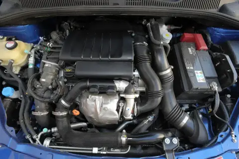 Silnik samochodowy Suzuki SX4 z widocznymi przewodami, akumulatorem i elementami układu dolotowego.