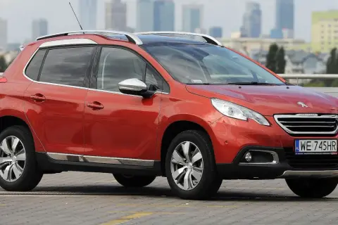 Pomarańczowy Peugeot 2008 na parkingu. Zastanawiasz się, jaki silnik wybrać do tego modelu?