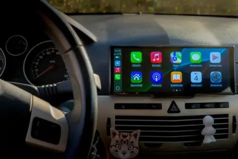 CarPlay co to? Ekran multimedialny w samochodzie z ikonami: Telefon, Muzyka, Mapy, Wiadomości, Samochód, Podcasty, Audiobooki, Kalendarz, Ustawienia.