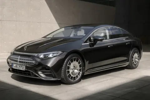 Elegancki, czarny Mercedes-Benz EQS, lśniący w słońcu, z charakterystycznym grillem i felgami.