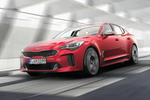 Czerwony Kia Stinger pędzi przez tunel. Sprawdź atrakcyjną kia stinger cena!
