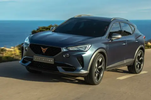 Niebieski SUV Cupra Formentor jedzie nad morzem. To jeden z wielu modeli, które można znaleźć, przeglądając marki samochodów alfabetycznie.