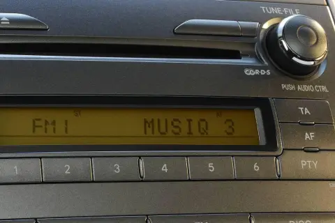 Radio samochodowe z wyświetlaczem RDS, pokazującym FM1 i MUSIQ 3. Przyciski numeryczne i sterowanie audio.