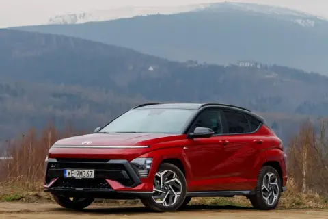 Czerwony Hyundai Kona na tle górskich krajobrazów. Wiele osób szuka Hyundai Kona opinie przed zakupem.