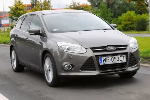 Szary Ford Focus MK3 1.6 TDCI w wersji kombi jedzie po drodze.