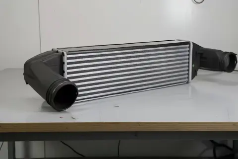 Chłodnica powietrza, czyli intercooler, z dwoma czarnymi wlotami po bokach.