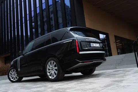 Elegancki czarny Range Rover Autobiography lśni na tle nowoczesnej architektury.