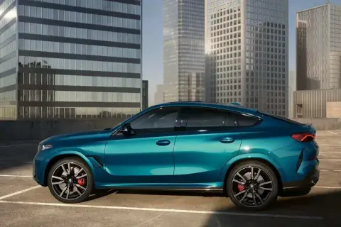 Błękitne x6 BMW lśni na tle nowoczesnych wieżowców.